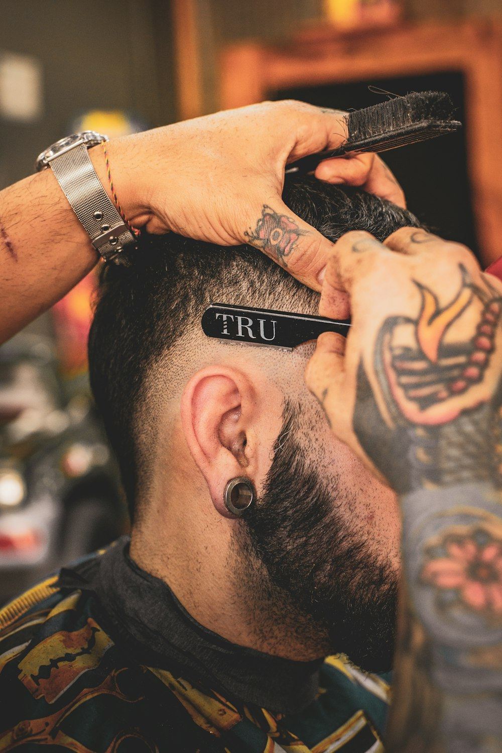 Happy barber smiling and giving a client a fresh skin fade